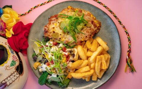 Crumbed chicken breast with chorizo, chunky corn, capsicum & bean salsa topped with cheese & guacamole. Served with Seasoned Fries & Side salad